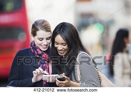 Women using cell phones on city street View Large Photo Image Stock Image - Women using cell phones on city street . Fotosearch