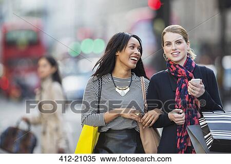 Stock Photography - Women walking together down city street. Fotosearch