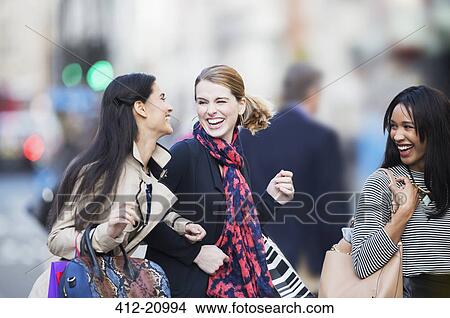 Picture - Women walking together on city street . Fotosearch