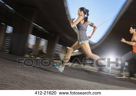 Couple running through city streets together View Large Photo Image Stock Image - Couple running through city streets together. Fotosearch