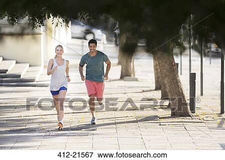 Stock Photo - Couple running through city streets together. Fotosearch