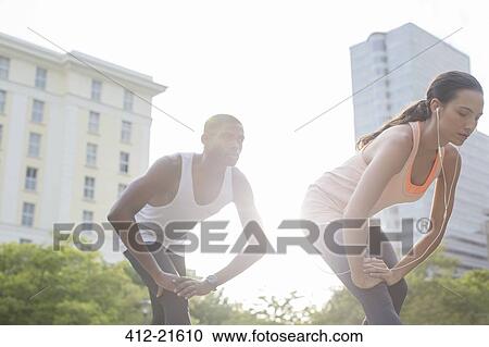 Couple stretching before exercising on city street View Large Photo Image Stock Image - Couple stretching before exercising on city street. Fotosearch
