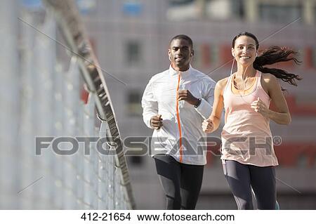 Friends running through city streets together View Large Photo Image Picture - Friends running through city streets together . Fotosearch