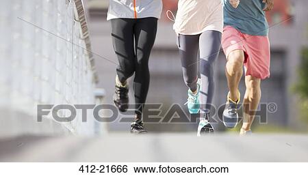 Friends running through city streets View Large Photo Image Stock Photograph - Friends running through city streets. Fotosearch