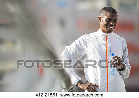 Stock Image - Man drinking water after exercising. Fotosearch