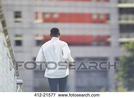 Stock Photo - Man running through city street . Fotosearch