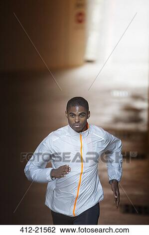 Man running through city streets View Large Photo Image Stock Image - Man running through city streets . Fotosearch