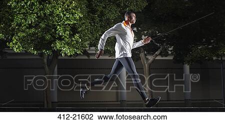 Man running through city streets View Large Photo Image Stock Image - Man running through city streets. Fotosearch