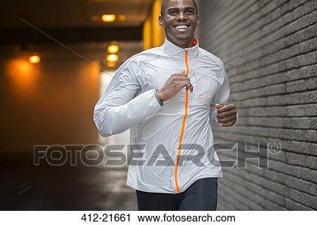 Stock Image - Man running through city streets . Fotosearch