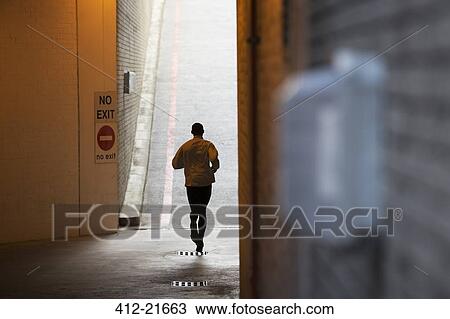 Stock Image - Man running through city streets . Fotosearch