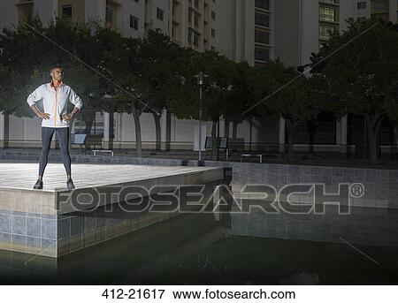 Stock Photo - Man standing in city park at night. Fotosearch