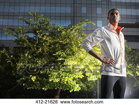 Stock Photo - Man standing in urban park at night . Fotosearch