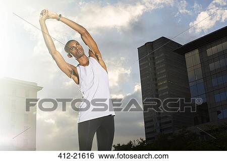 Stock Photograph - Man stretching before exercising on city street. Fotosearch