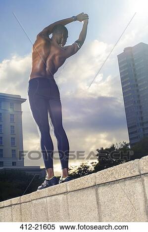 Stock Photography - Man stretching before exercising on city street. Fotosearch