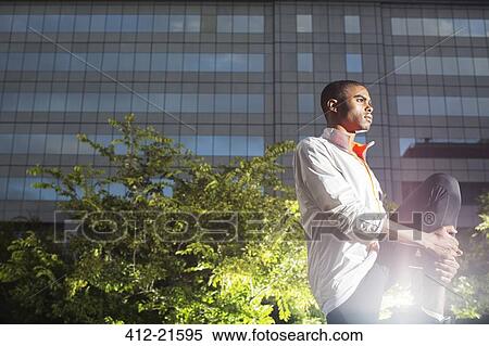 Stock Photography - Man stretching his legs before exercising. Fotosearch