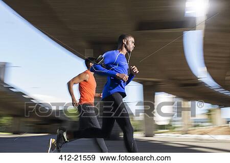 Stock Photo - Men running together through city . Fotosearch