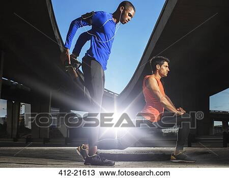 Men stretching before exercising on city street View Large Photo Image Stock Image - Men stretching before exercising on city street. Fotosearch