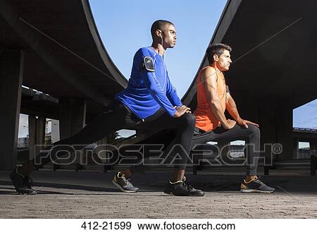 Stock Photo - Men stretching before exercising on city street. Fotosearch