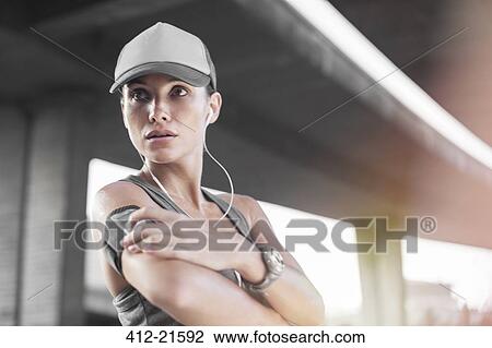Stock Image - Woman playing music before exercising. Fotosearch