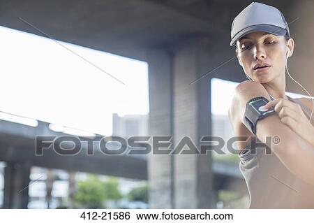 Woman playing music before exercising View Large Photo Image Stock Photograph - Woman playing music before exercising. Fotosearch