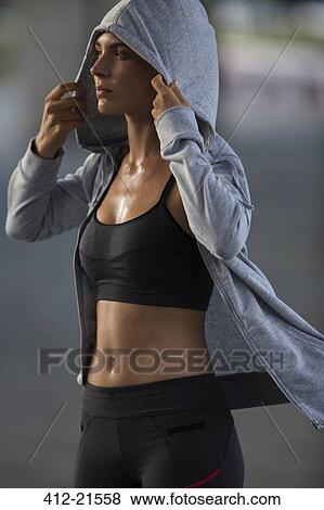 Woman putting on sweatshirt after exercise View Large Photo Image Stock Photo - Woman putting on sweatshirt after exercise. Fotosearch