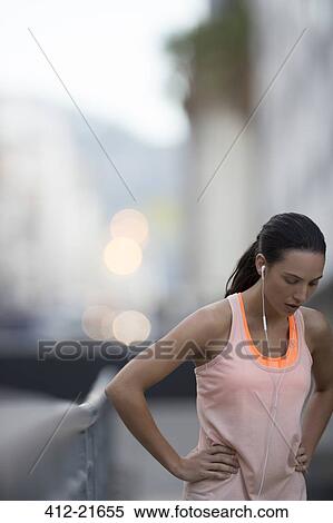 Woman resting after running on city street View Large Photo Image Stock Photography - Woman resting after running on city street. Fotosearch