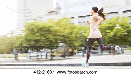 Stock Photo - Woman running through city streets. Fotosearch