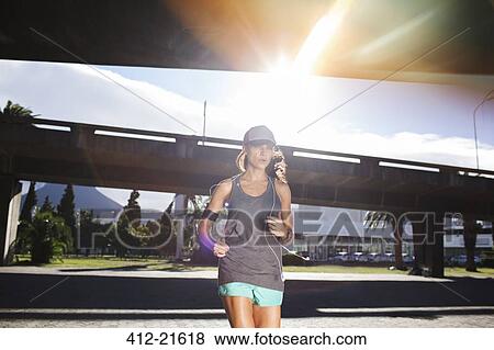 Stock Photo - Woman running through city streets . Fotosearch