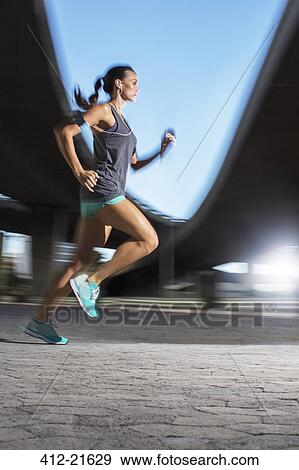 Woman running through city streets View Large Photo Image Stock Photo - Woman running through city streets. Fotosearch