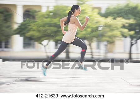 Woman running through city streets View Large Photo Image Stock Photo - Woman running through city streets. Fotosearch