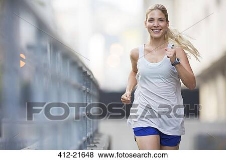 Stock Photo - Woman running through city streets. Fotosearch