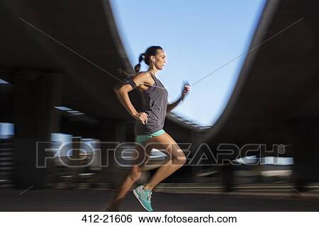 Woman running through city streets View Large Photo Image Stock Photograph - Woman running through city streets . Fotosearch