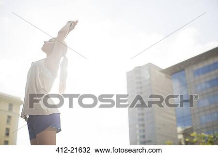Woman stretching before exercising on city street View Large Photo Image Stock Image - Woman stretching before exercising on city street. Fotosearch