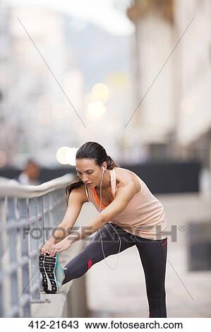 Woman stretching before exercising on city street View Large Photo Image Stock Image - Woman stretching before exercising on city street. Fotosearch