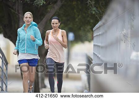 Women running through city streets together View Large Photo Image Stock Image - Women running through city streets together. Fotosearch
