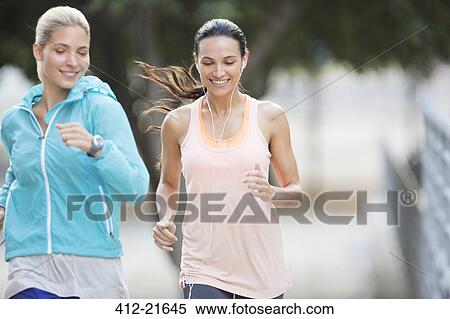Stock Photography - Women running through city streets together. Fotosearch