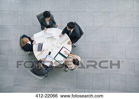 Business people having meeting at table View Large Photo Image Stock Photograph - Business people having meeting at table. Fotosearch