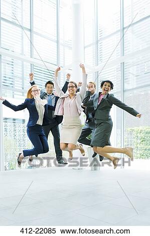 Business people jumping in office building View Large Photo Image Stock Photography - Business people jumping in office building. Fotosearch