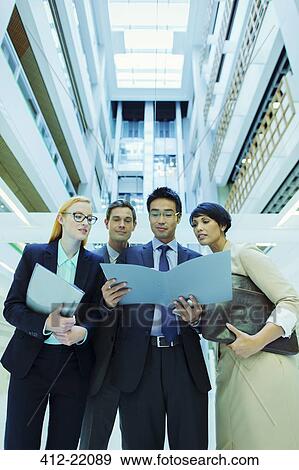Business people looking at file in office building View Large Photo Image Stock Photo - Business people looking at file in office building. Fotosearch