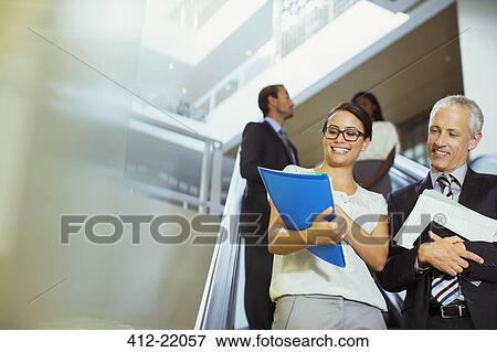 Stock Photo - Business people looking over documents in office building . Fotosearch