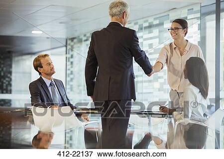 Business people shaking hands in office building View Large Photo Image Stock Photo - Business people shaking hands in office building. Fotosearch