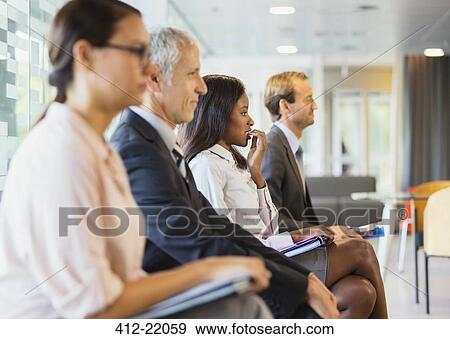 Stock Photo - Business people sitting in office together. Fotosearch