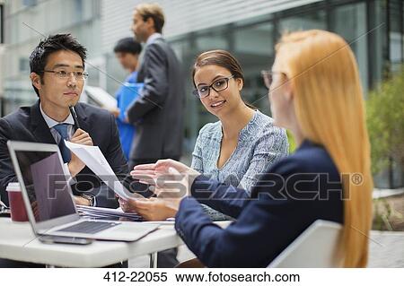 Stock Photography - Business people talking at outdoor table . Fotosearch