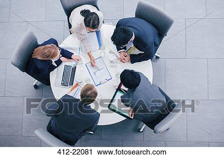 Stock Image - Business people talking in meeting at table. Fotosearch