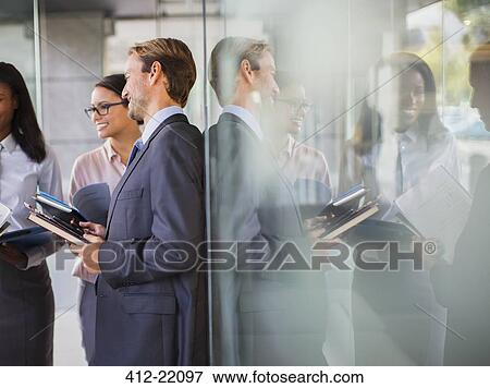 Stock Photo - Business people talking in office building. Fotosearch