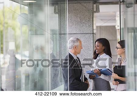 Business people talking in office building View Large Photo Image Stock Photo - Business people talking in office building. Fotosearch