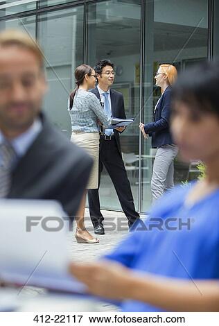 Stock Photo - Business people talking outside of office building. Fotosearch