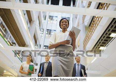Stock Photo - Business people walking in office building . Fotosearch