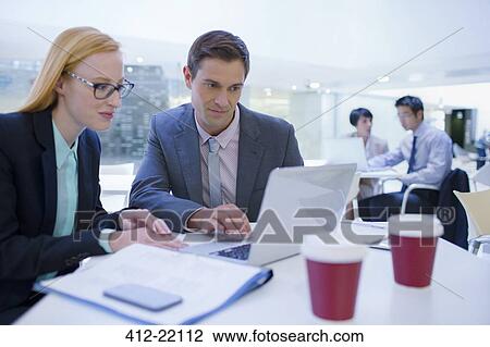 Business people working on laptops at table View Large Photo Image Stock Image - Business people working on laptops at table. Fotosearch