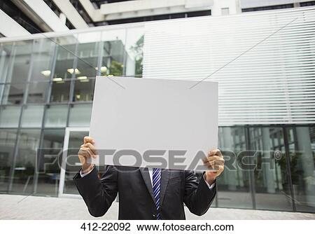 Businessman holding document in office building View Large Photo Image Stock Image - Businessman holding document in office building. Fotosearch